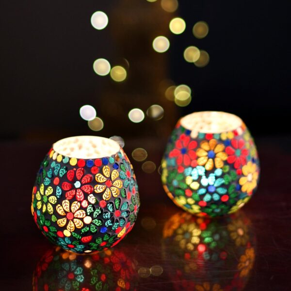 Floral design mosaic tealight holders on wooden table